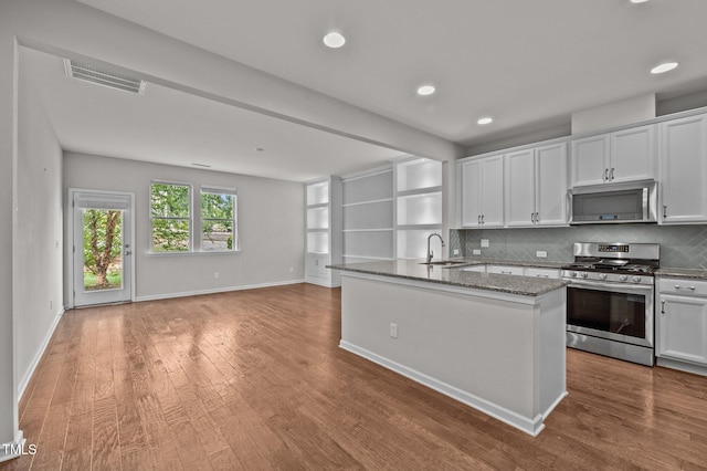 256 Rubrum Dr, Hillsborough, NC 27278 - kitchen featuring stainless steel appliances, wood finished floors, stone countertops, white cabinets, and decorative backsplash