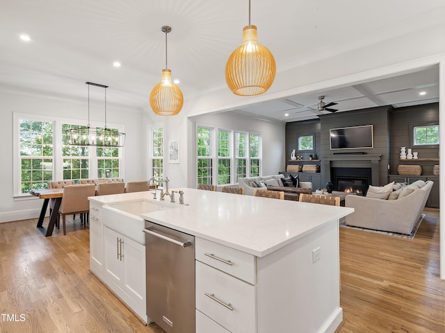 3160 Mantle Ridge Dr, Apex, NC 27502 - kitchen with dishwasher, a ceiling fan, a glass covered fireplace, a sink, and an island with sink
