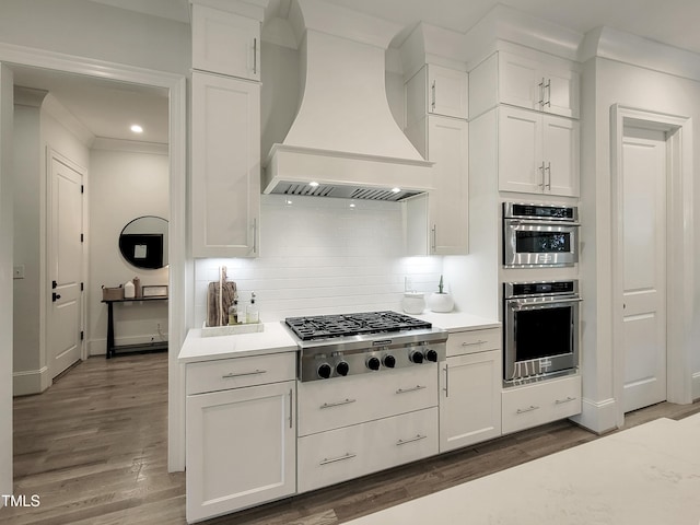 3160 Mantle Ridge Dr, Apex, NC 27502 - kitchen featuring stainless steel appliances, wall chimney exhaust hood, wood finished floors, light countertops, and crown molding