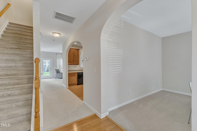 711 Keystone Park Dr Unit 7, Morrisville, NC 27560 - hallway with stairway, light carpet, arched walkways, baseboards, and light wood finished floors