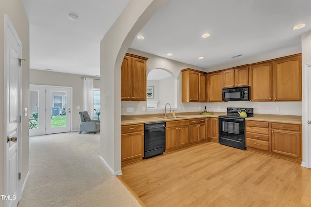 711 Keystone Park Dr Unit 7, Morrisville, NC 27560 - kitchen with black appliances, a sink, light countertops, arched walkways, and brown cabinets