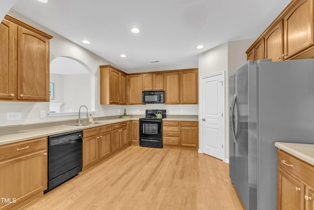 711 Keystone Park Dr Unit 7, Morrisville, NC 27560 - kitchen featuring black appliances, a sink, light wood-style floors, recessed lighting, and arched walkways