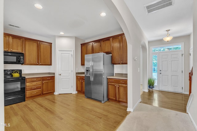 711 Keystone Park Dr Unit 7, Morrisville, NC 27560 - kitchen with black appliances, arched walkways, light countertops, light wood-style flooring, and baseboards