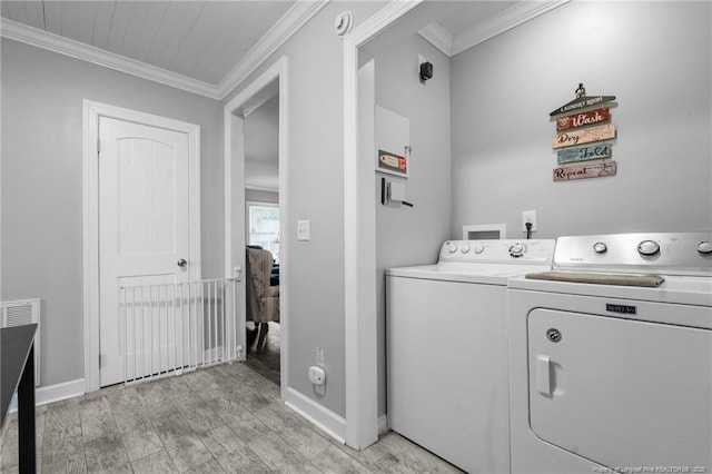 521 Cedar Creek Rd, Fayetteville, NC 28312 - clothes washing area with washing machine and dryer, crown molding, baseboards, and light wood-type flooring