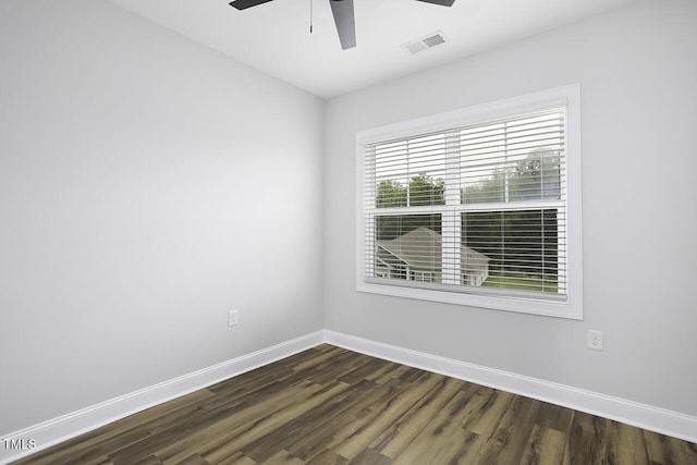 unfurnished room with a ceiling fan, baseboards, and dark wood-type flooring