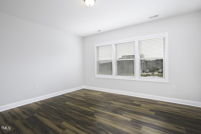 empty room featuring baseboards and dark wood-style flooring