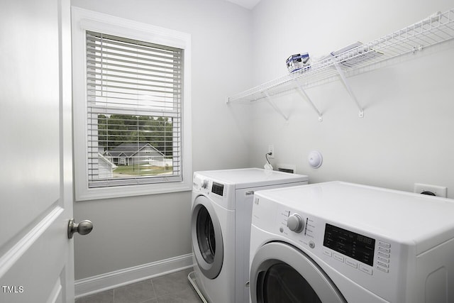 laundry room featuring separate washer and dryer, tile patterned flooring, and baseboards