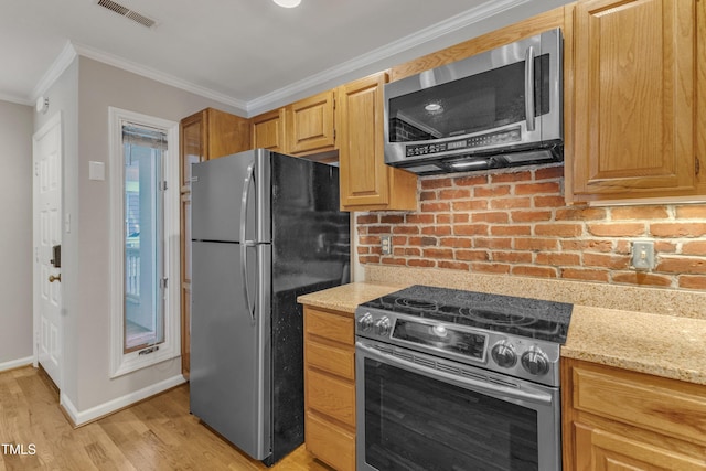 kitchen with appliances with stainless steel finishes, crown molding, light wood-style flooring, light stone countertops, and baseboards