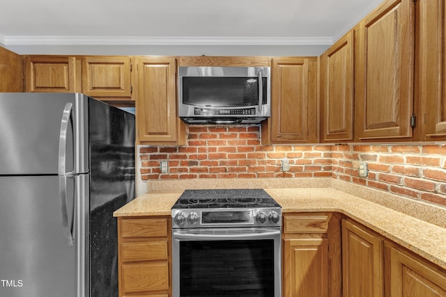 kitchen featuring appliances with stainless steel finishes, light stone countertops, and crown molding