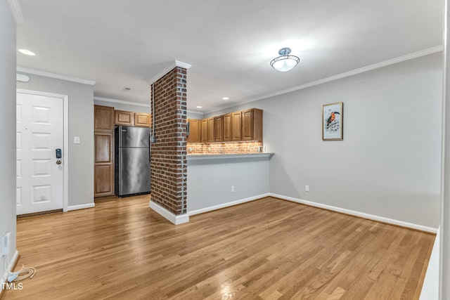 unfurnished living room featuring light wood finished floors, ornamental molding, baseboards, and recessed lighting