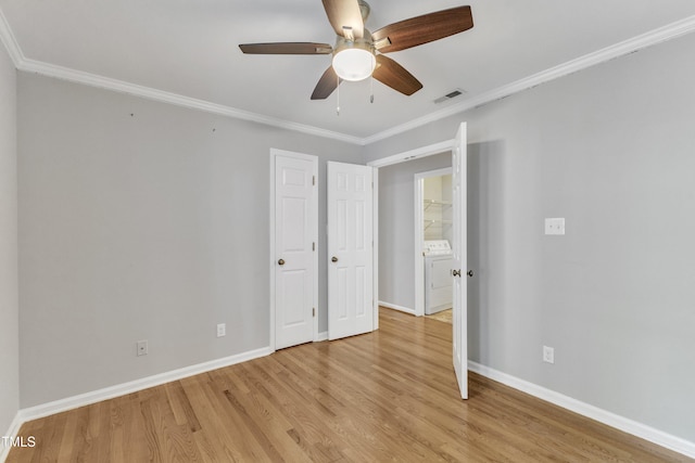 unfurnished bedroom featuring light wood-type flooring, washer / clothes dryer, crown molding, baseboards, and a ceiling fan