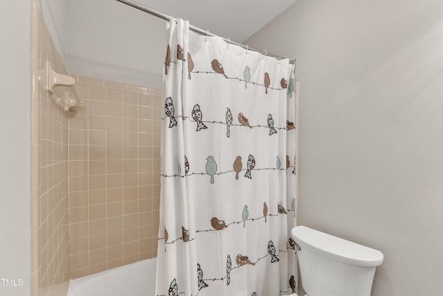 bathroom featuring toilet and shower / bath combination with curtain