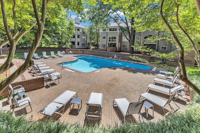 community pool featuring a patio area and fence