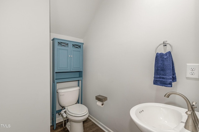 1230 Adrian Ct, Mebane, NC 27302 - half bathroom featuring a sink, wood finished floors, toilet, baseboards, and vaulted ceiling