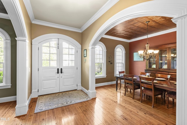 1329 Wynncrest Ct, Raleigh, NC 27603 - foyer entrance with arched walkways, light wood-style flooring, a chandelier, baseboards, and ornamental molding