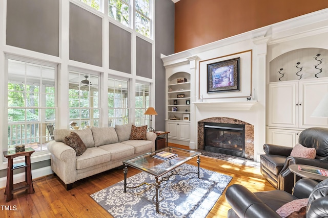 1329 Wynncrest Ct, Raleigh, NC 27603 - living area with plenty of natural light, hardwood / wood-style floors, a premium fireplace, built in shelves, and a high ceiling