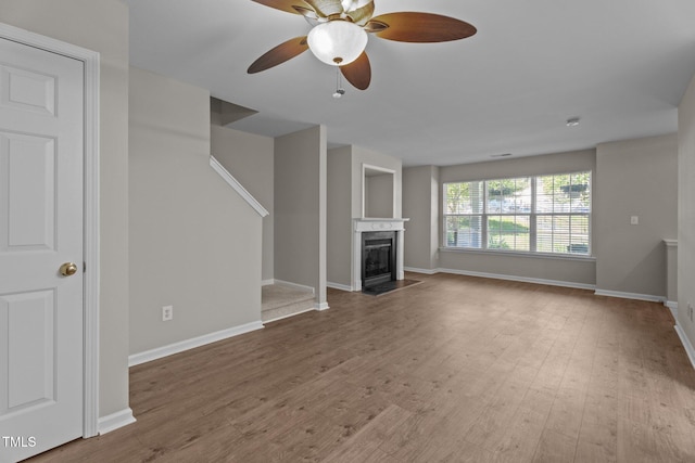1313 Legacy Greene Ave, Wake Forest, NC 27587 - unfurnished living room featuring ceiling fan, wood finished floors, baseboards, and stairway