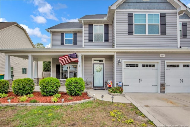 3821 Shire St, Hope Mills, NC 28348 - view of front of home featuring an attached garage, concrete driveway, covered porch, and stone siding