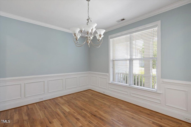 120 Tanager Farms Dr, Youngsville, NC 27596 - spare room with a chandelier, ornamental molding, a wainscoted wall, and wood finished floors