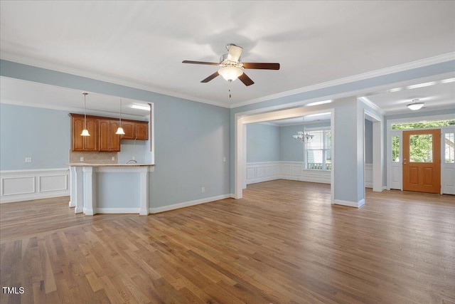 120 Tanager Farms Dr, Youngsville, NC 27596 - unfurnished living room with a chandelier, ceiling fan, wood finished floors, crown molding, and wainscoting