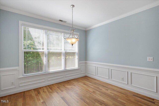 120 Tanager Farms Dr, Youngsville, NC 27596 - spare room featuring plenty of natural light, light wood-style flooring, wainscoting, and ornamental molding