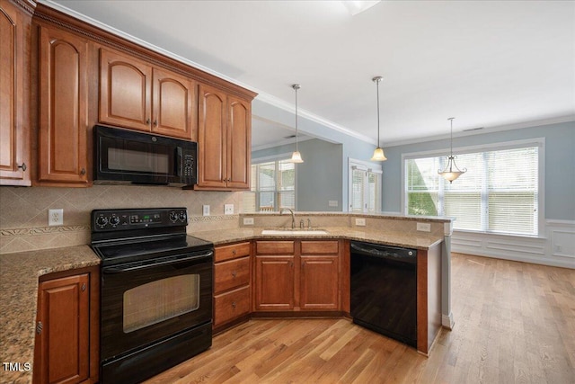 120 Tanager Farms Dr, Youngsville, NC 27596 - kitchen with black appliances, a sink, light wood-style floors, plenty of natural light, and ornamental molding