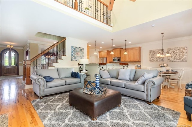  - living room with ornamental molding, a chandelier, stairs, light wood-style flooring, and recessed lighting