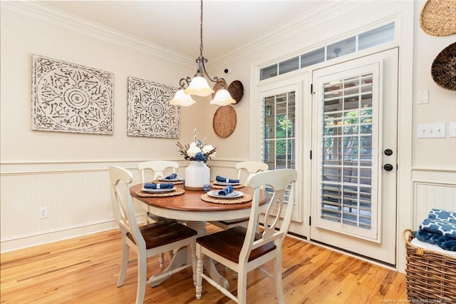  - dining area with light wood-type flooring, crown molding, and wainscoting