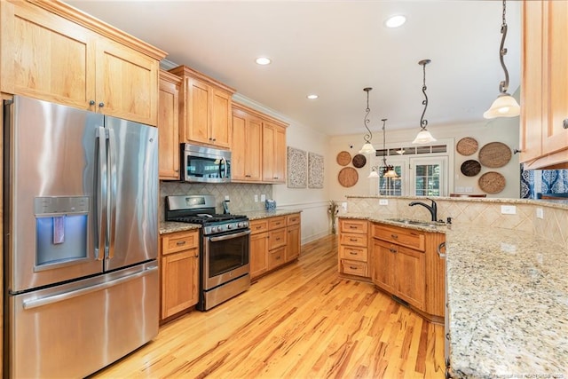  - kitchen featuring stainless steel appliances, light wood-style floors, decorative backsplash, a peninsula, and recessed lighting