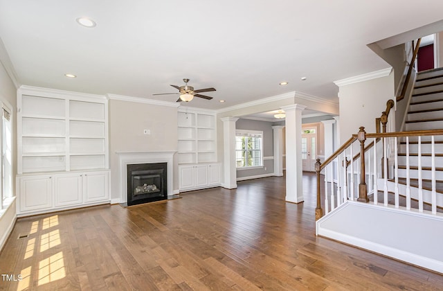 123 Gunderson Ln, Garner, NC 27529 - unfurnished living room featuring a ceiling fan, decorative columns, ornamental molding, built in shelves, and stairway