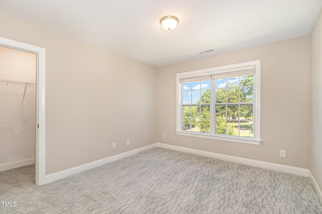 123 Gunderson Ln, Garner, NC 27529 - unfurnished bedroom with a walk in closet, baseboards, carpet flooring, and a closet