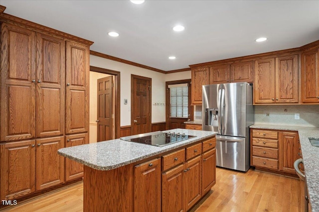 8133 Holly Forest Rd, Wake Forest, NC 27587 - kitchen with stainless steel fridge with ice dispenser, black electric cooktop, ornamental molding, brown cabinetry, and a wainscoted wall