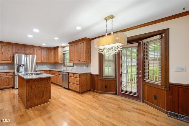 8133 Holly Forest Rd, Wake Forest, NC 27587 - kitchen with stainless steel appliances, wainscoting, a sink, light wood-style floors, and healthy amount of natural light