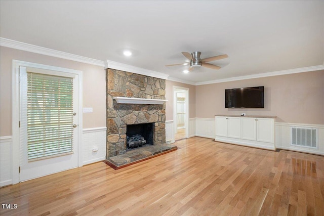 8133 Holly Forest Rd, Wake Forest, NC 27587 - unfurnished living room featuring crown molding, ceiling fan, a fireplace, wainscoting, and wood finished floors