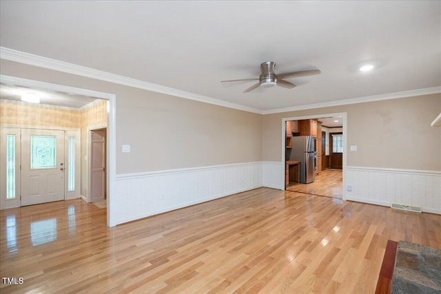 8133 Holly Forest Rd, Wake Forest, NC 27587 - unfurnished living room featuring a ceiling fan, wood finished floors, wainscoting, and crown molding