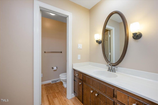 8133 Holly Forest Rd, Wake Forest, NC 27587 - bathroom featuring toilet, vanity, wood finished floors, and baseboards