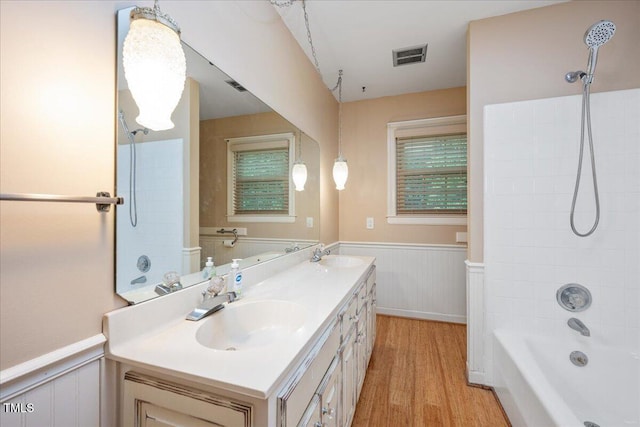 8133 Holly Forest Rd, Wake Forest, NC 27587 - bathroom with wood finished floors, a wainscoted wall, double vanity, and shower / bath combination