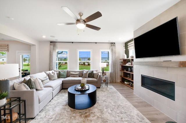 living room featuring light wood finished floors, a fireplace, plenty of natural light, and recessed lighting