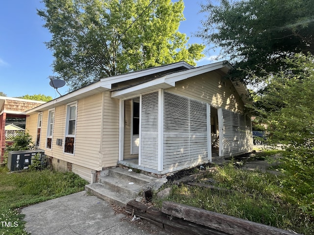 view of property exterior featuring central air condition unit and entry steps