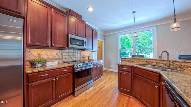 8042 Hogan Dr, Wake Forest, NC 27587 - kitchen with stainless steel appliances, ornamental molding, a sink, light wood-type flooring, and tasteful backsplash