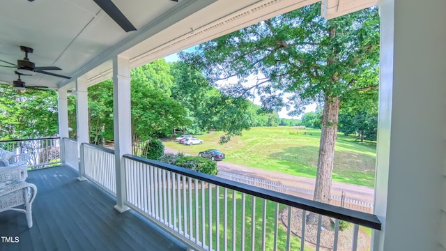 8042 Hogan Dr, Wake Forest, NC 27587 - wooden porch featuring a ceiling fan, a lawn, and view of scattered trees