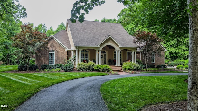 3197 Carriage Creek Ct, Haw River, NC 27258 - view of front of house with a front yard, brick siding, a porch, and a shingled roof