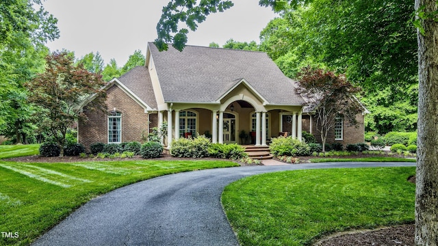 3197 Carriage Creek Ct, Haw River, NC 27258 - view of front of property featuring a front lawn, brick siding, curved driveway, and a shingled roof