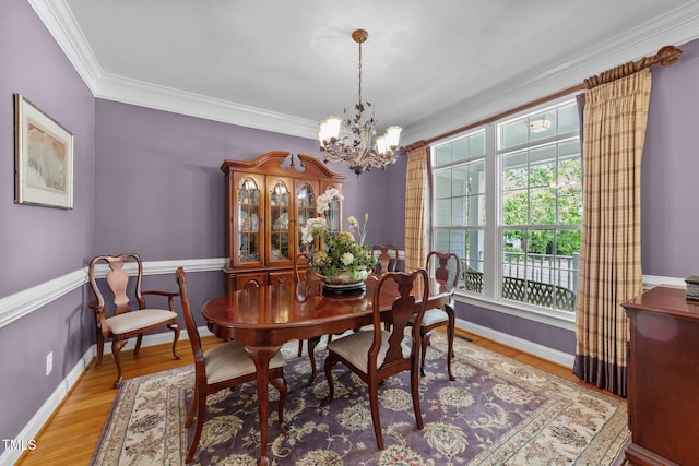 3923 Napa Valley Dr, Raleigh, NC 27612 - dining room featuring a chandelier, ornamental molding, wood finished floors, and baseboards