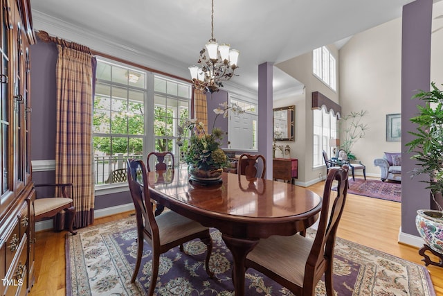 3923 Napa Valley Dr, Raleigh, NC 27612 - dining room with a chandelier, crown molding, light wood-type flooring, and baseboards