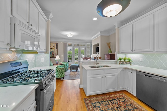 3923 Napa Valley Dr, Raleigh, NC 27612 - kitchen with appliances with stainless steel finishes, a sink, light countertops, white cabinetry, and ornamental molding