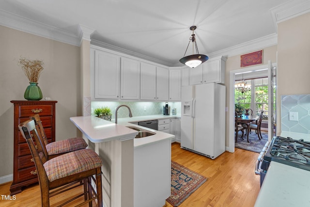 3923 Napa Valley Dr, Raleigh, NC 27612 - kitchen featuring white fridge with ice dispenser, a sink, range with gas cooktop, light countertops, and a peninsula