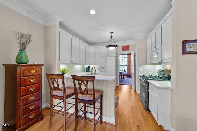 3923 Napa Valley Dr, Raleigh, NC 27612 - kitchen with white appliances, light countertops, a peninsula, white cabinets, and crown molding