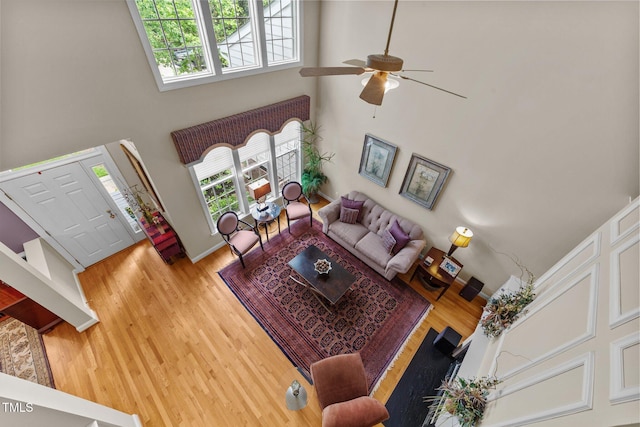 3923 Napa Valley Dr, Raleigh, NC 27612 - living area featuring a towering ceiling, ceiling fan, wood finished floors, and baseboards