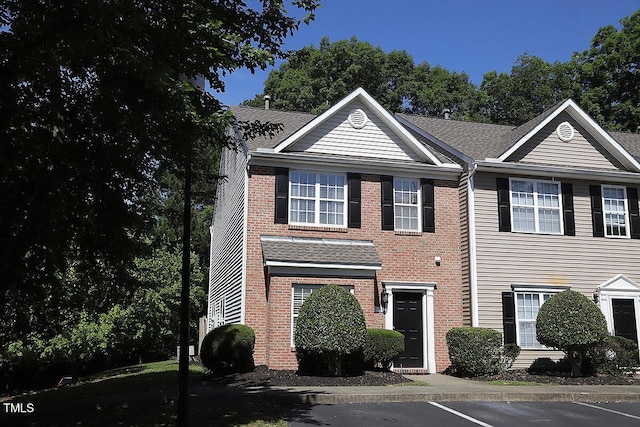 view of front of house featuring brick siding and uncovered parking